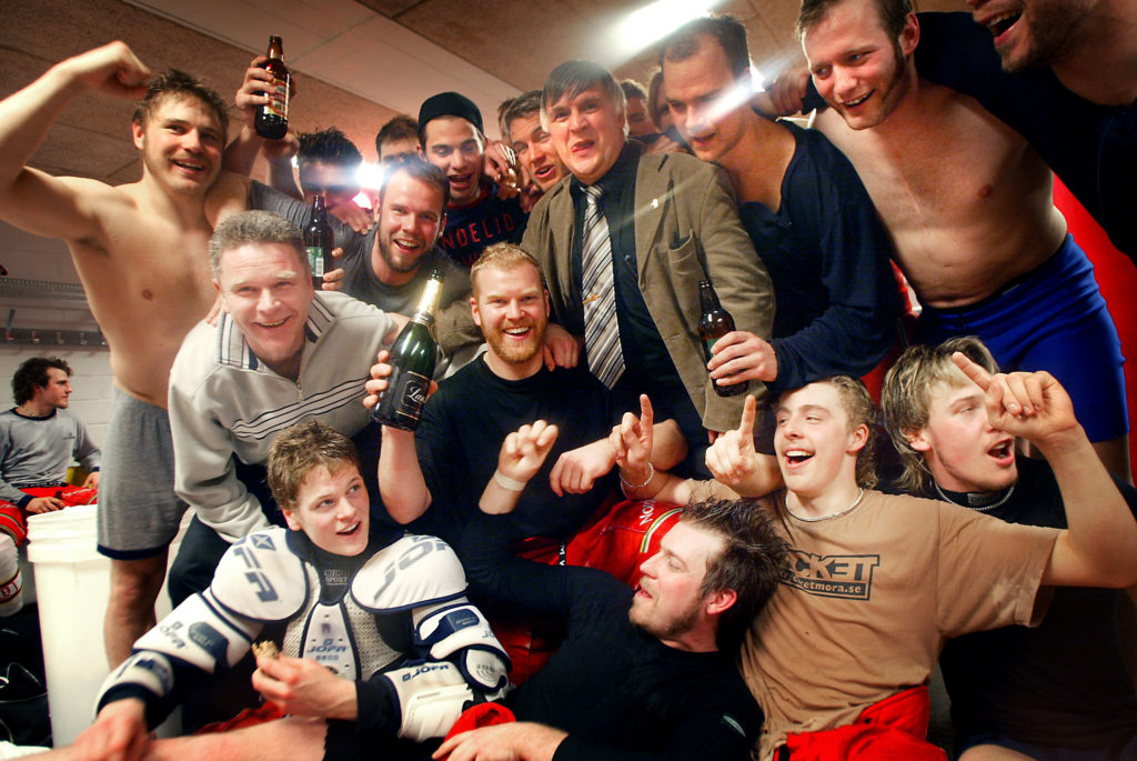 Tränaren Harald Lückner (grå tröja) och legendariske klubbdirektören Jan Simons (brun kavaj) jublar med laget efter segern. Foto: MAGNUS WENNMAN